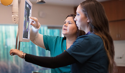 Dos profesionales de la salud observan el monitor clínico